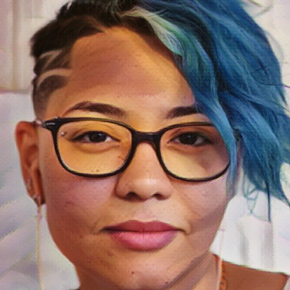 Close up of young person with eye glasses and short blue hair 