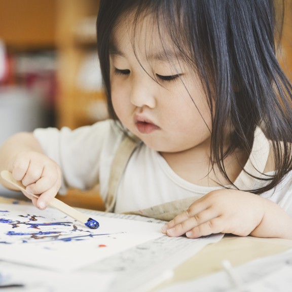 young child coloring in a book