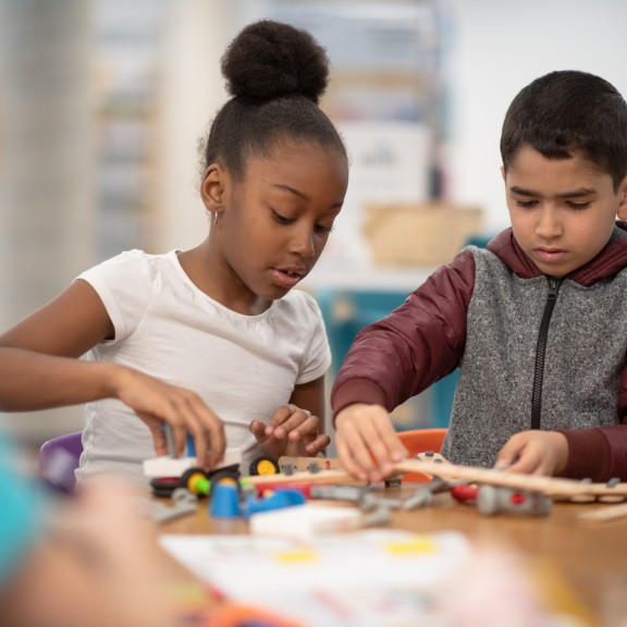 Young girl and boy playing with blocks at school