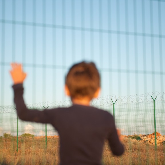 Child at metal fence