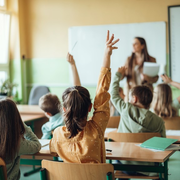 Students raising their hands in class