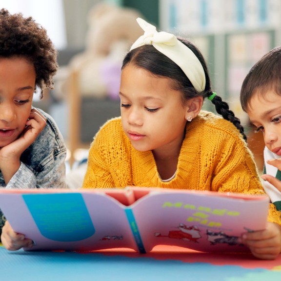 Young children reading a book at school