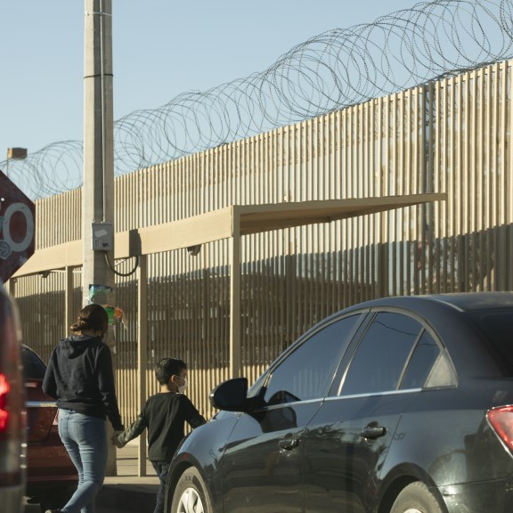 Mother and child walk near U.S.-Mexico border crossing