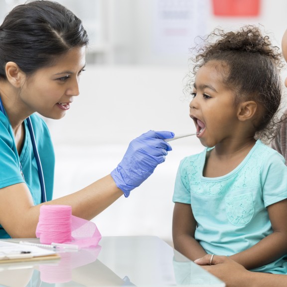 Pediatrician examines young patient