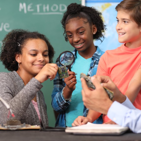 Diverse group of students building a robot in class