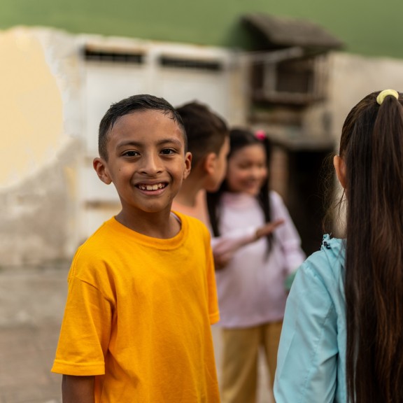 Hispanic boy playing with friends outside