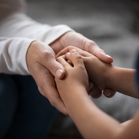 Foster parent holding hands of young girl