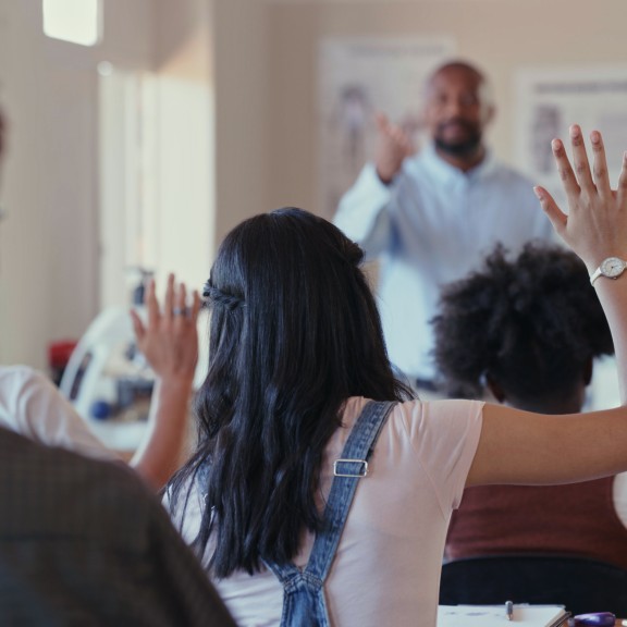 Students raising their hands in class