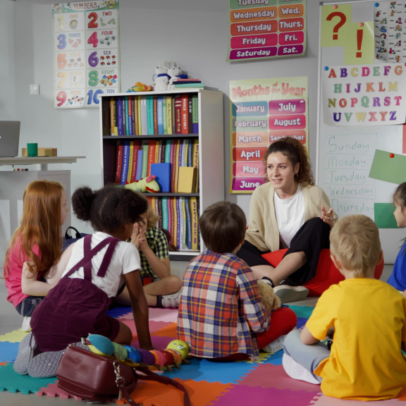 Students sitting with their teacher in class