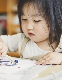 young child coloring in a book