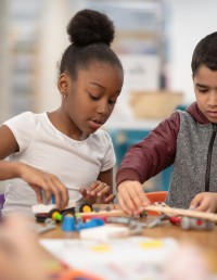 Young girl and boy playing with blocks at school