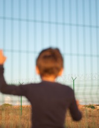 Child at metal fence