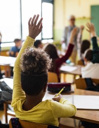 Children raising hands in class