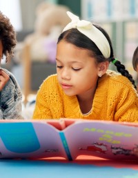 Young children reading a book at school