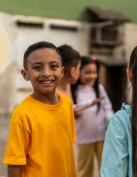 Hispanic boy playing with friends outside