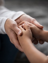 Foster parent holding hands of young girl