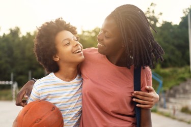 Parent and teen smiling with basketball