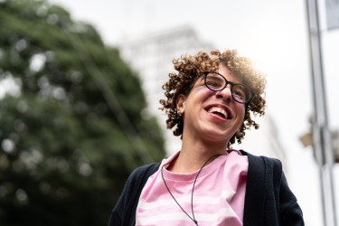 Happy smiling young person with short curly blond hair
