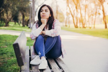 Young person sitting outside on a bench.jpg